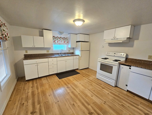 kitchen featuring dark countertops, white cabinetry, a sink, white appliances, and under cabinet range hood