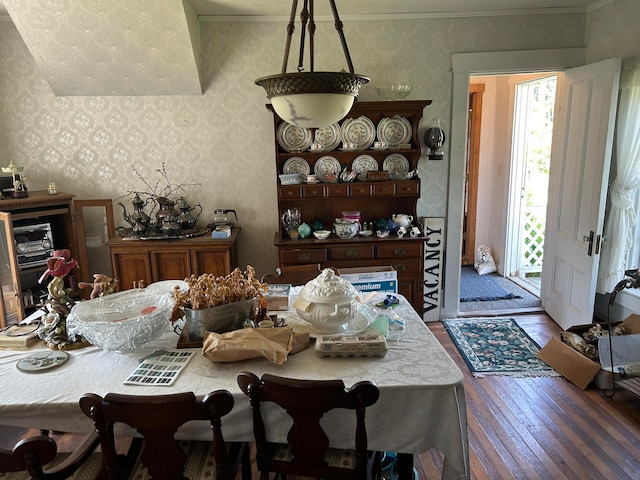 dining room with hardwood / wood-style flooring and crown molding