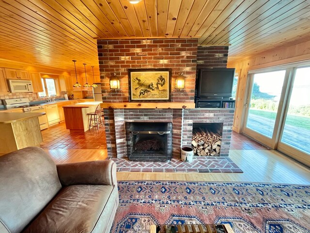 living room with a brick fireplace, hardwood / wood-style flooring, and wood ceiling