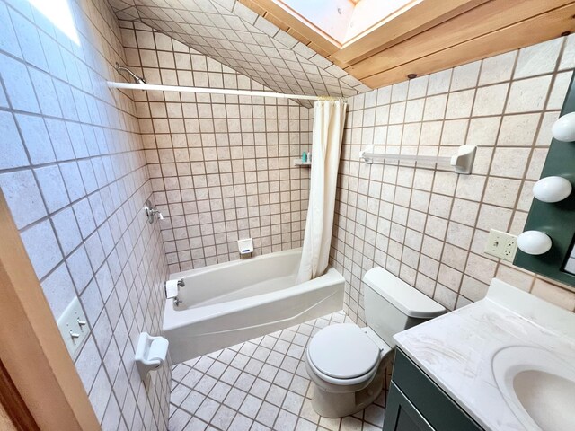 full bathroom featuring toilet, tile walls, shower / tub combo with curtain, tile patterned floors, and vanity