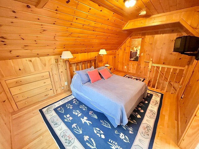 bedroom with wooden ceiling, wooden walls, lofted ceiling, and hardwood / wood-style flooring