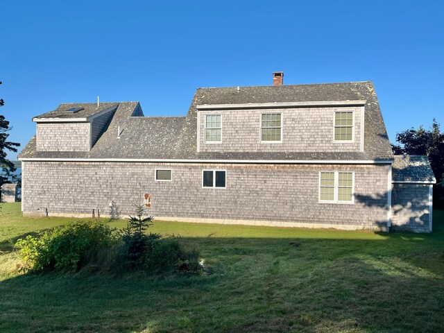 rear view of house featuring a yard