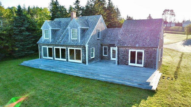 back of property featuring a lawn and a deck