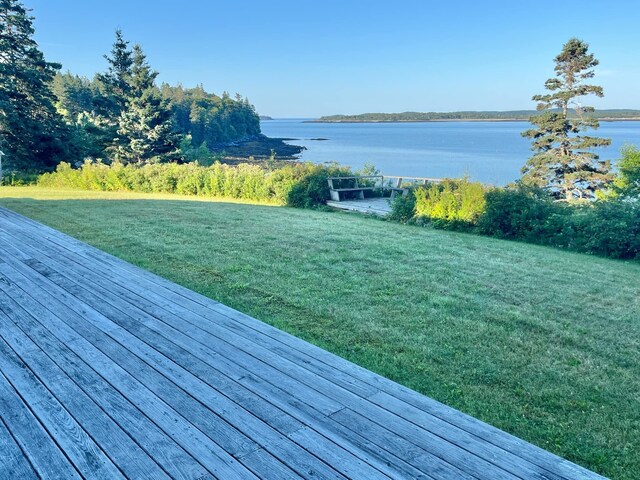 deck with a lawn and a water view