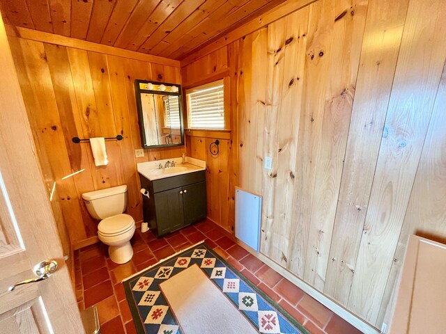 bathroom with wood ceiling, toilet, wood walls, tile patterned floors, and vanity