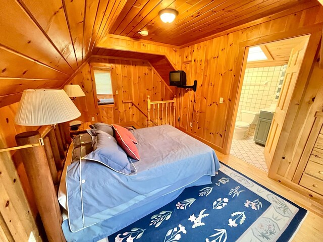 bedroom with wood walls, hardwood / wood-style flooring, wood ceiling, and connected bathroom