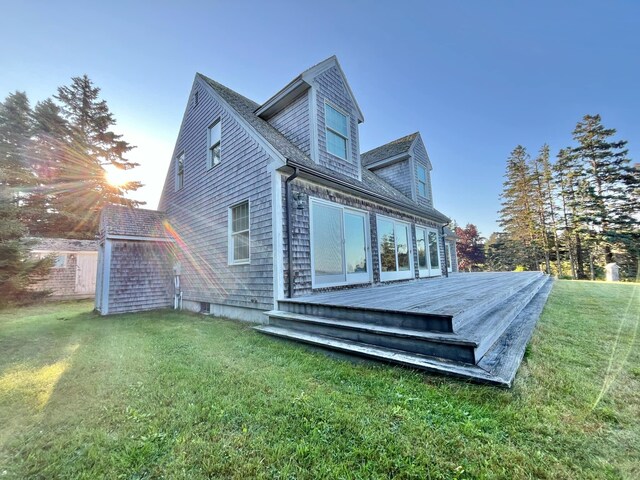 back of property with a wooden deck and a yard