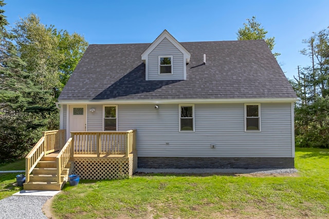 back of property featuring a wooden deck and a lawn