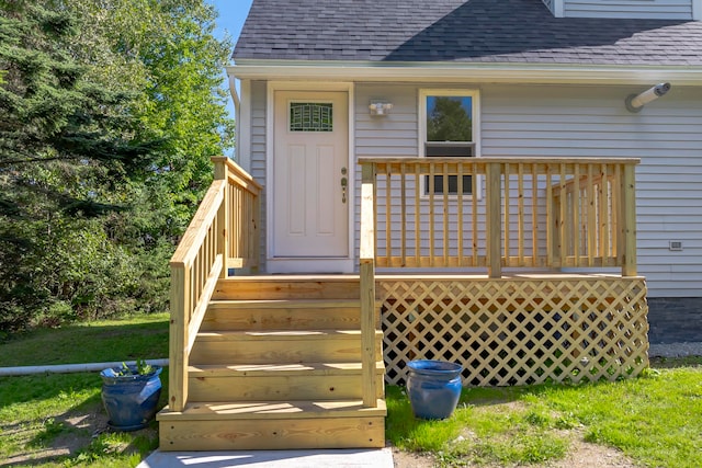 entrance to property with a yard and a wooden deck