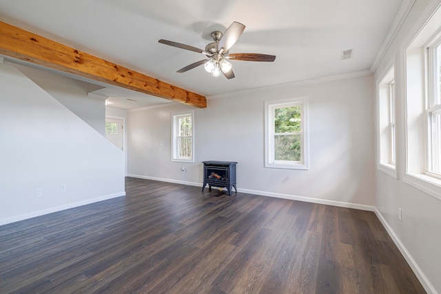 unfurnished living room with ceiling fan, beamed ceiling, a wood stove, ornamental molding, and dark hardwood / wood-style flooring