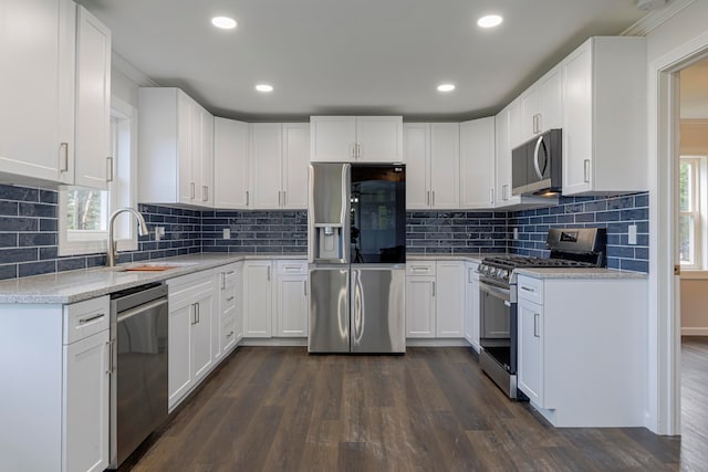 kitchen with decorative backsplash, white cabinets, stainless steel appliances, and dark hardwood / wood-style flooring