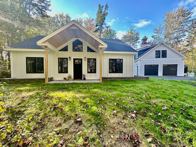 modern farmhouse featuring roof with shingles, board and batten siding, and a front yard