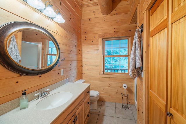 full bathroom with a shower with door, toilet, wood walls, vanity, and tile patterned flooring