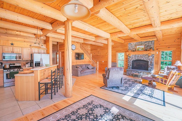 living area with light wood-type flooring, wood ceiling, and wood walls