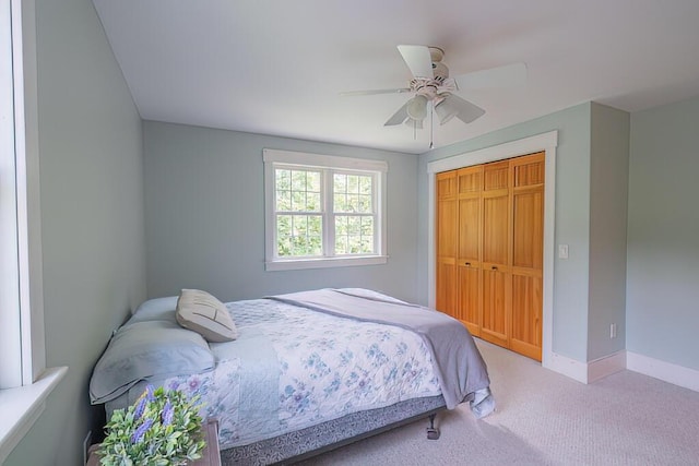 carpeted bedroom featuring a closet, a ceiling fan, and baseboards