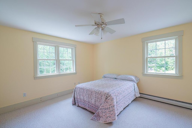 bedroom with ceiling fan, baseboard heating, and carpet