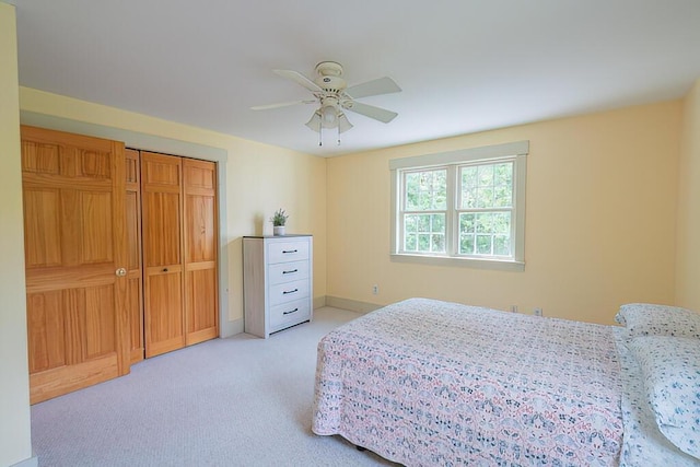 bedroom with baseboards, a ceiling fan, and light colored carpet