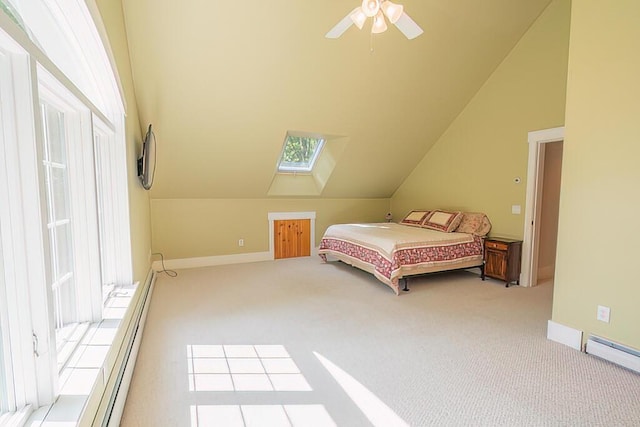 bedroom with vaulted ceiling with skylight, baseboard heating, carpet flooring, and baseboards