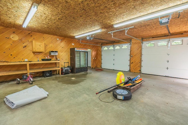 garage with a garage door opener and wooden walls