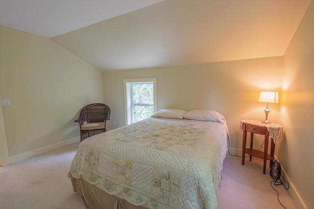 bedroom with lofted ceiling, light carpet, and baseboards