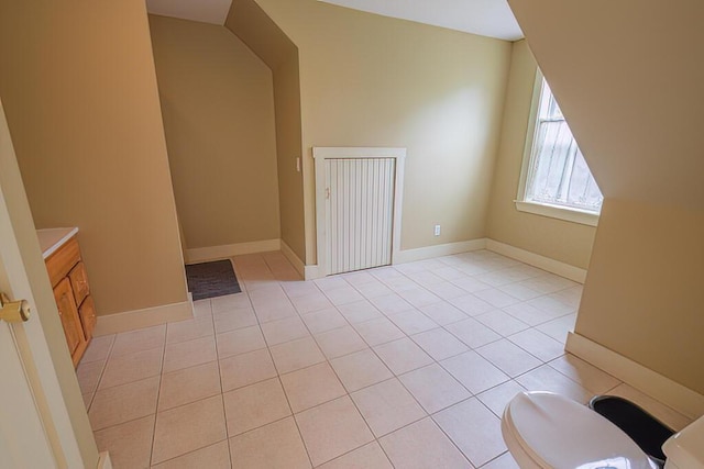 additional living space featuring baseboards and light tile patterned floors