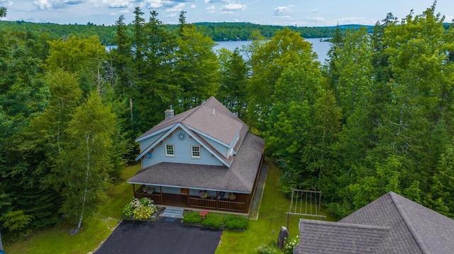 drone / aerial view featuring a water view and a forest view
