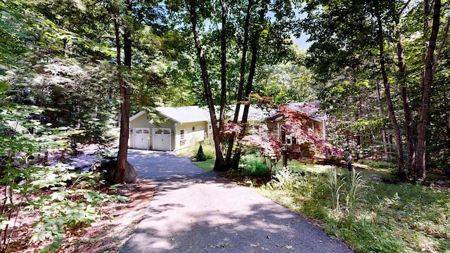 obstructed view of property with a garage and aphalt driveway