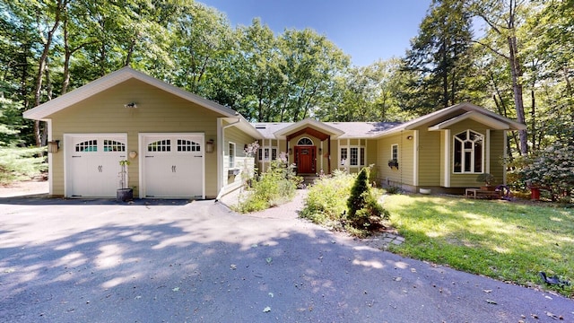 single story home featuring a garage and aphalt driveway