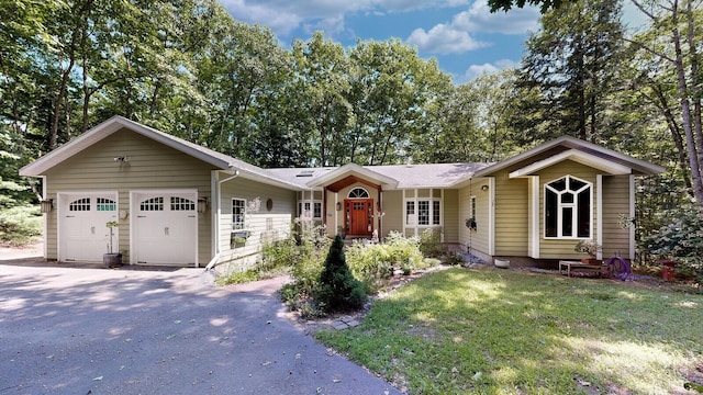 ranch-style house featuring a front yard, driveway, and an attached garage