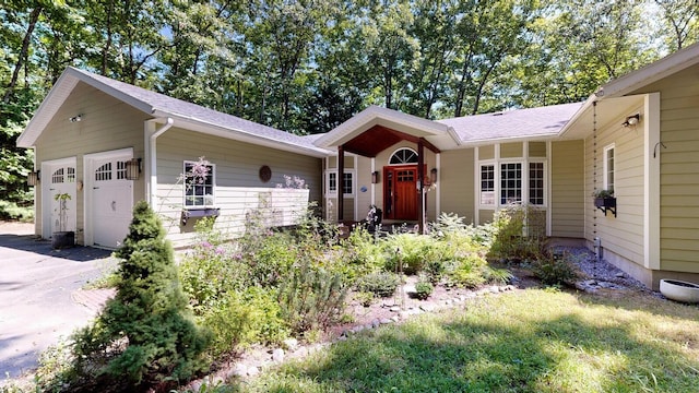 single story home with aphalt driveway and an attached garage