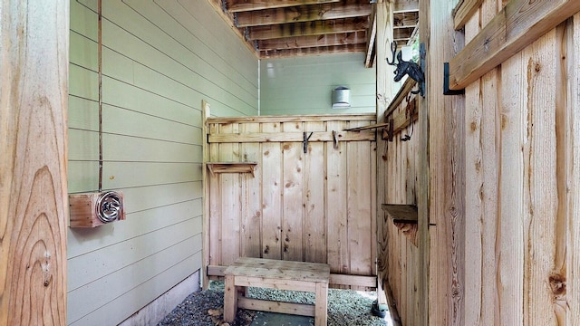 mudroom featuring wooden walls