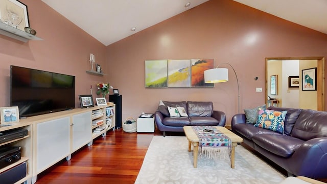 living room featuring dark wood-type flooring and vaulted ceiling