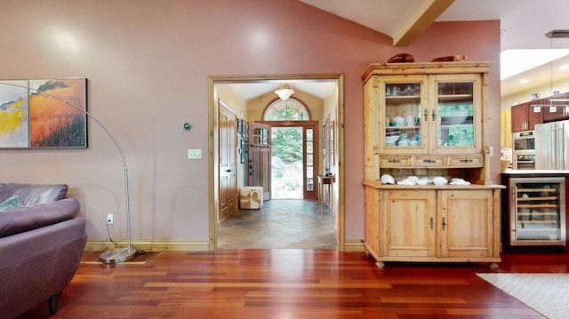 interior space featuring lofted ceiling, wine cooler, baseboards, and dark wood-type flooring