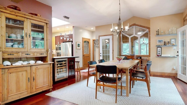 dining room with lofted ceiling, dark wood-style floors, beverage cooler, and an inviting chandelier