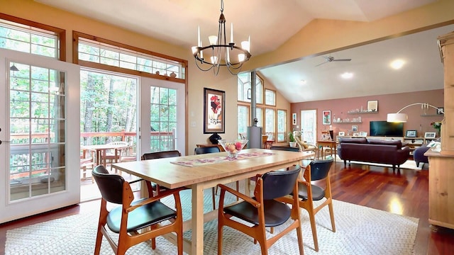 dining room featuring ceiling fan with notable chandelier, high vaulted ceiling, wood finished floors, and a wealth of natural light