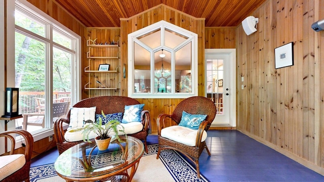 sitting room with a healthy amount of sunlight, wood ceiling, and wooden walls