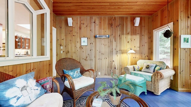 living area featuring wooden ceiling, wooden walls, and wood finished floors