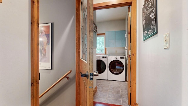 laundry area with light tile patterned floors, separate washer and dryer, and cabinet space