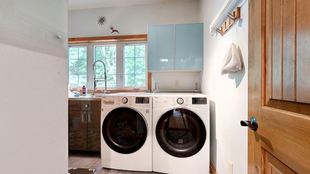 laundry area with separate washer and dryer, a sink, and cabinet space