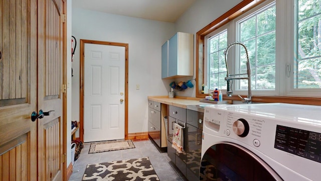 laundry area with washer / dryer, light tile patterned floors, baseboards, and cabinet space