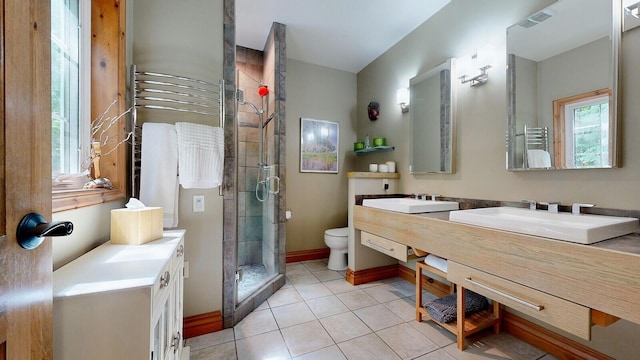 full bath featuring a stall shower, tile patterned flooring, a sink, and toilet