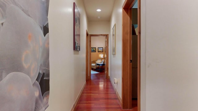 corridor with dark wood-type flooring, recessed lighting, and baseboards