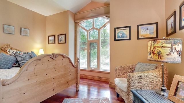 living area with vaulted ceiling, wood finished floors, and baseboards