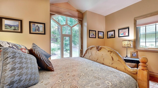 bedroom with vaulted ceiling and multiple windows