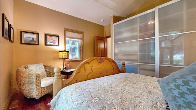 bedroom featuring vaulted ceiling and dark wood-style flooring