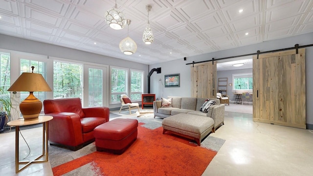 living area with a wood stove, a wealth of natural light, a barn door, and an ornate ceiling