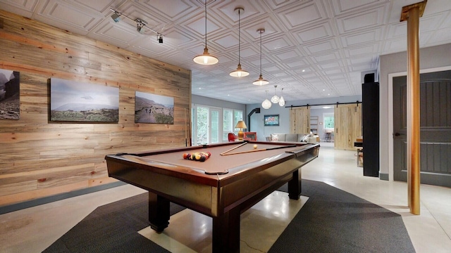 recreation room featuring an ornate ceiling, a barn door, wooden walls, and pool table