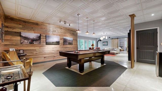 game room featuring an ornate ceiling, pool table, wooden walls, and a barn door