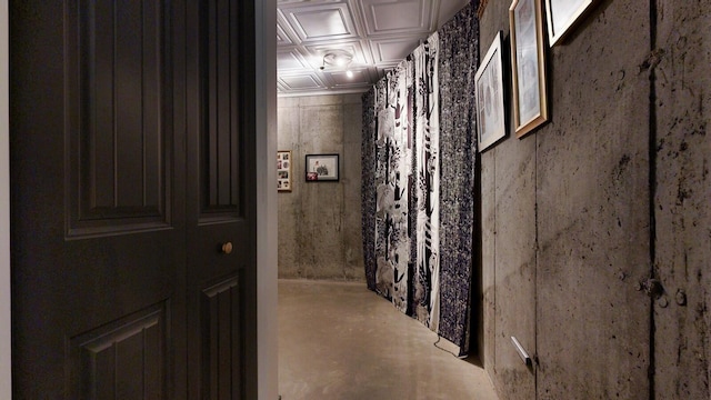 hall with concrete floors and an ornate ceiling