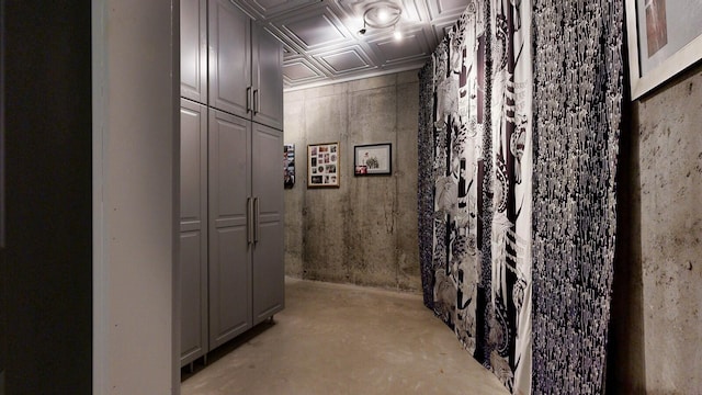 corridor featuring concrete floors and an ornate ceiling